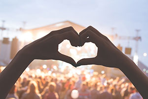 Woman at medicine festival making a love heart with her hand