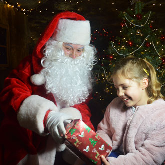 Santa giving a child a present in Charlestown Longest Festive Light Tunnel 